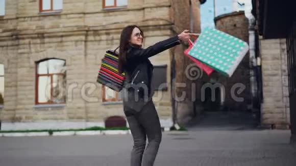 快乐的购物狂在户外跳舞的慢镜头写真视频的预览图
