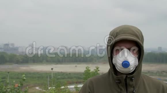 年轻人站在城市的背景下戴着医用口罩在浓密的烟雾中视频的预览图
