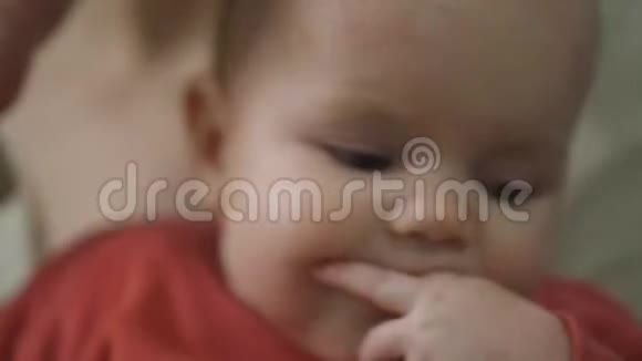 一个一岁的小女孩吮吸手指她的牙齿被刺穿了孩子看着镜头视频的预览图