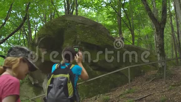 徒步旅行团的游客在丛林野生自然公园的山上带背包的美女拍照视频的预览图