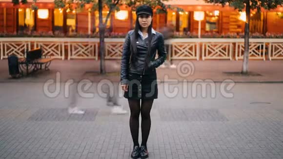 穿时髦衣服的严肃亚洲人晚上站在街上看着的延时肖像视频的预览图