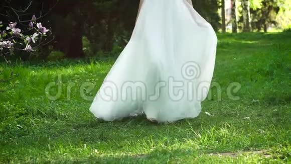 身着长裙的新娘在绿草地上慢镜头视频的预览图