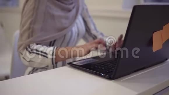 微笑自信的穆斯林女性戴着头巾坐在现代会议厅的白色椅子上视频的预览图