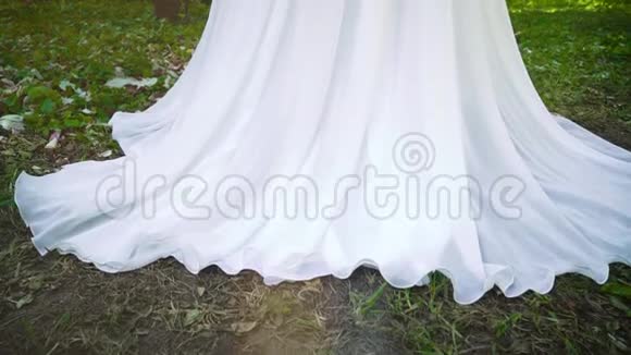 在盛开的花园里新娘穿着白色长裙的小镜头视频的预览图
