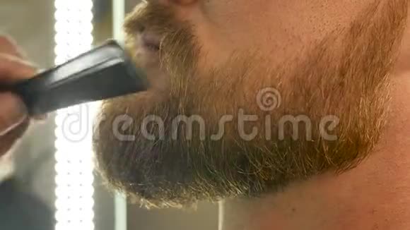 理发店老板给准备理发的男人梳胡子和胡子给男人开美容院视频的预览图