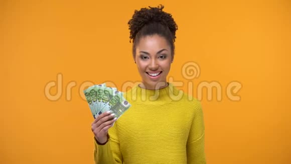 漂亮的黑人女士展示了一大堆欧元和OK手势现金返还服务视频的预览图
