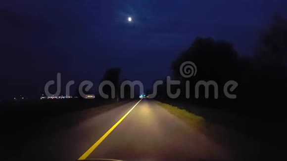 驱车穿过乡村接近地平线上的城市灯光驾驶视角POV驶入城市视频的预览图