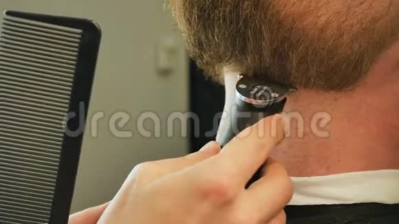 理发师大师用电动剃须刀把胡子的形状从较低的角度拍摄美丽视频的预览图