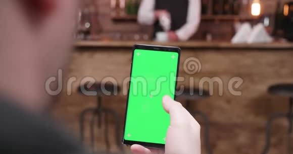 男人用绿色屏幕在手机上滑动视频的预览图
