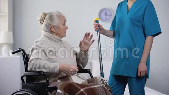 坐在轮椅上健谈的老太太和医院看门人闲聊孤独视频的预览图