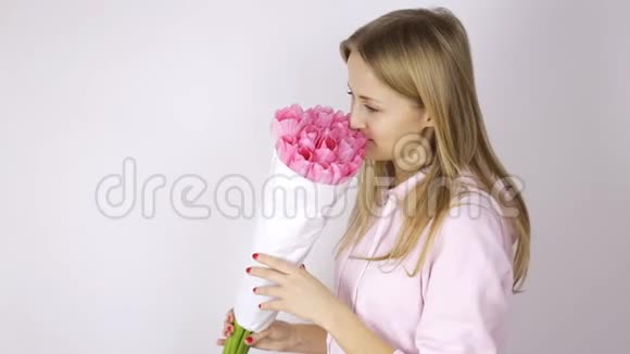 女人看着一束粉红色的郁金香视频的预览图