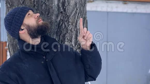 冬天的时候可怜的胡子男戴着耳机食指朝上视频的预览图