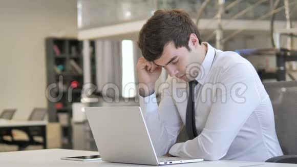 疲倦的年轻商人在工作时睡觉工作量大视频的预览图