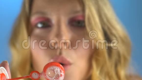 年轻女子吹肥皂泡回到童年心情好特写镜头视频的预览图