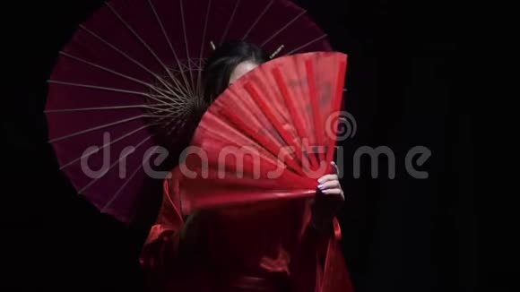 可爱的亚洲女人展开一个红色的扇子然后遮住她的脸视频的预览图