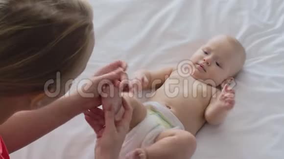 一个女人按摩女婴脚和她玩视频的预览图