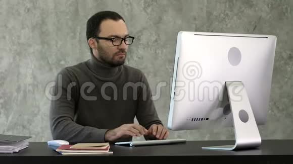 方案拟订在IT办公室工作的人坐在办公桌前写代码程序员键入数据代码工作视频的预览图