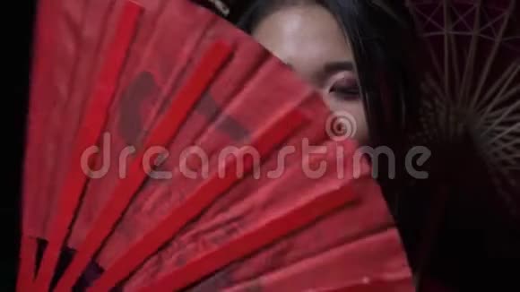 漂亮的日本女士展开一个扇子然后微笑遮住她的一半脸闭上眼睛视频的预览图