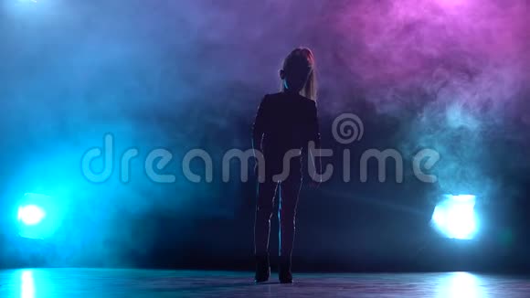 女孩站起来抬起腿多色烟雾背景剪影从后面的光慢动作视频的预览图