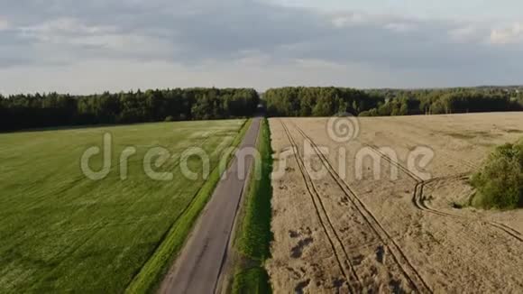 农业方面的直线道路人骑摩托车在夕阳下经过现场空中观景4K视频的预览图