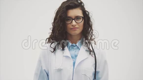 一个穿着医用晨衣手里拿着一个药罐的年轻医生姑娘女人被隔离在灰色的视频的预览图