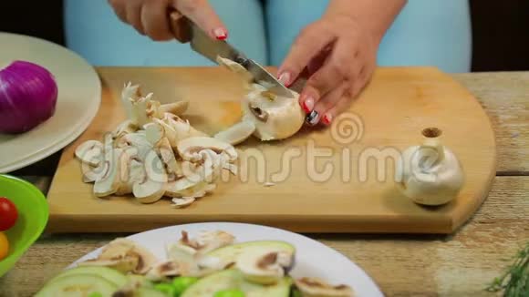 一个女人用一把刀在木板上把香瓜蘑菇切成薄片时间跨度视频的预览图