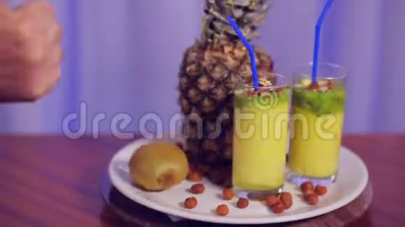 一个杯子上面放着水果和坚果的白色盘子和一个手势课视频的预览图