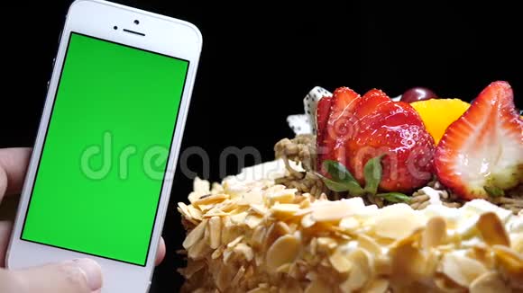 潘拍水果生日蛋糕手拿绿色屏幕手机视频的预览图