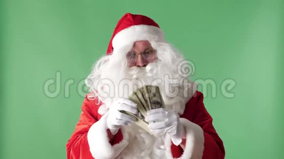满意的圣诞老人把钞票扔出一捆钱雨概念绿色的背景视频的预览图