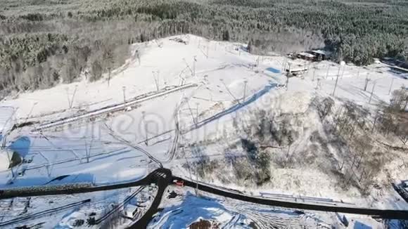 冬季大型滑雪场的空中观景台道路被森林包围的山坡以蓝色衬托视频的预览图