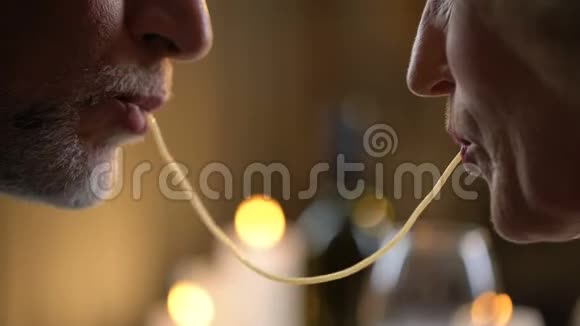 浪漫的老夫妇吃意大利面和接吻男人和女人约会晚餐视频的预览图