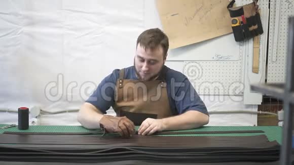男皮工人在工作室缝制黑色长细节视频的预览图