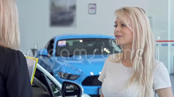 一位美女在汽车经销店和售货员交谈视频的预览图