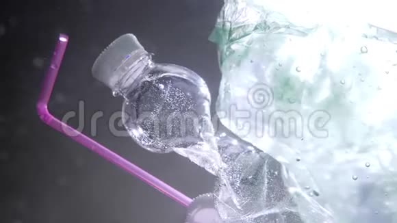 塑料瓶吸管和漂浮在海洋中的垃圾的特写镜头全球海洋污染问题视频的预览图