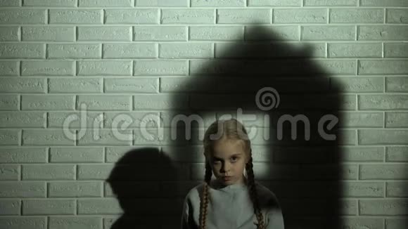小女孩身后墙上的房子影子孤儿需要家和家庭视频的预览图