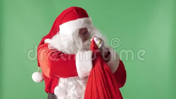 圣诞老人从一个红色的袋子里拿了一堆钞票背景是绿色的概念钞票视频的预览图