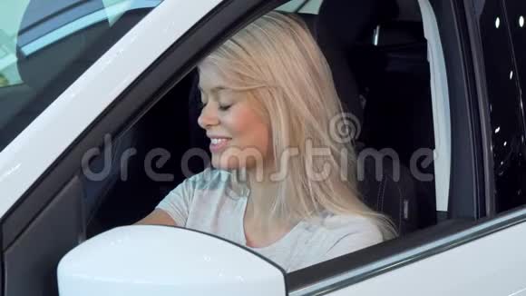 漂亮的女人坐在车里看着侧镜视频的预览图
