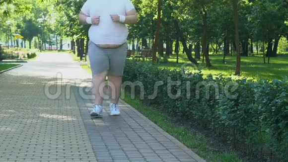 大腹便便的胖子一大早在公园跑步渴望减肥视频的预览图