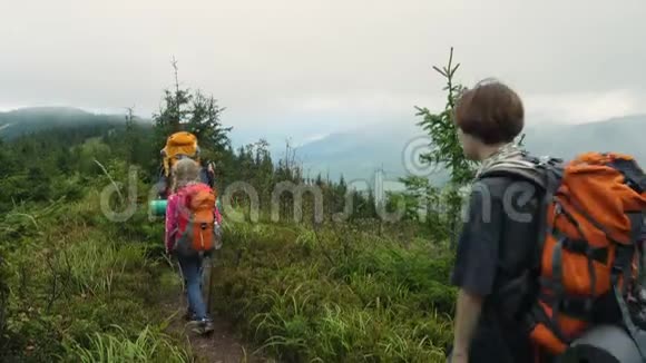 在山上徒步旅行的家庭成人和儿童背包客视频的预览图