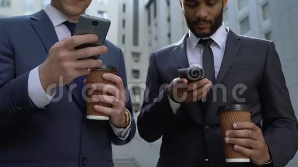 忙碌的男人每天24小时在咖啡休息时看智能手机上的新闻视频的预览图