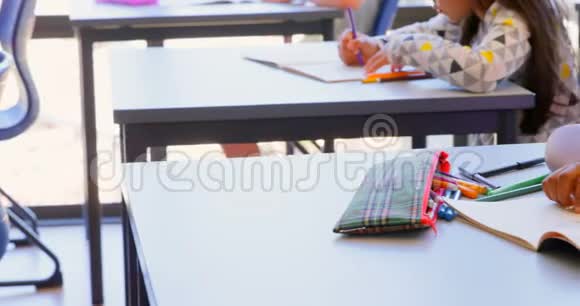 在教室的桌子上睡在书上的女学生视频的预览图
