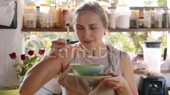 年轻快乐的女人在厨房里品尝食物视频的预览图