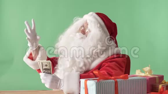 满足圣诞老人把钞票从一捆钱扔在桌子上金钱概念色彩在背景视频的预览图