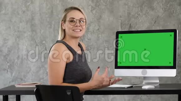 商务女士在办公室里和摄像机对着电脑屏幕说话绿屏模拟显示视频的预览图
