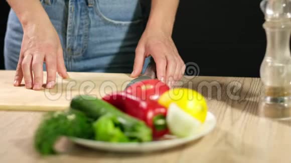 一个年轻的女人正在煮生的蔬菜一个年轻的女人切了一个成熟的西红柿视频的预览图