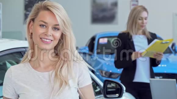 漂亮的幸福女人微笑着买了新车后拿着车钥匙视频的预览图