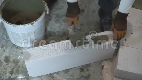 施工人员用手高角度拍摄用抹子将砂浆抹在砌块侧面视频的预览图