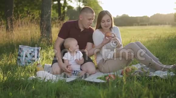 快乐的一家人在日落公园里度过了夏天的第一次野餐视频的预览图