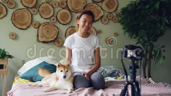 这位迷人的年轻女士正在录制关于宠物狗的视频与追随者交谈抚摸可爱的动物笑着和抚摸视频的预览图