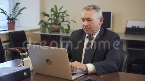 高级企业家西装革履在办公室工作的笔记本电脑视频的预览图